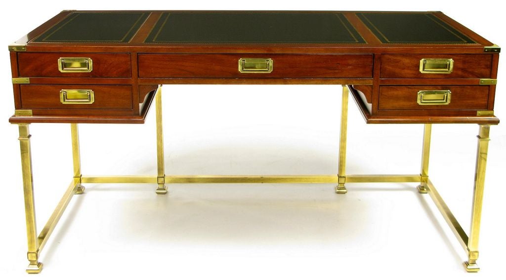 A classic form, accented by the brass base, this campaign desk is of a size to fit in many locations.  Brass bound corners, and flush campaign pulls contrast nicely with the mahogany finish, and gilt black leather top.  Also a perfect writing table,