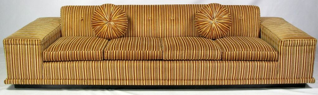This massive four seat sofa is covered with impeccable vintage cut velvet upholstery, in a bold orange, gold, white and black stripe.  The sofa sits on a recessed plinth base in ebony cerused oak.  <br />
<br />
Much like the designs of Paul