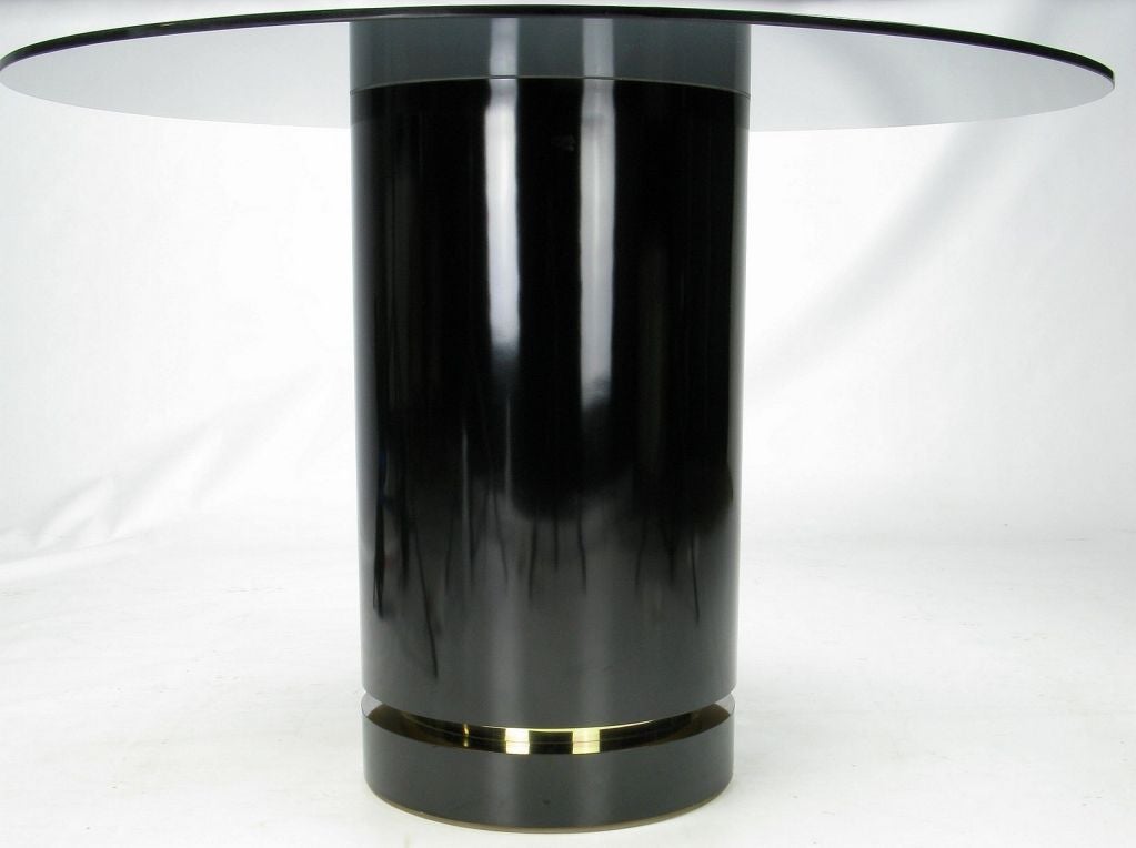 This sleek Milo Baughman center table is comprised of a black laminated pedestal, circumscribed with a recessed brass ring that is subtly inset into a negative reveal. 1/2