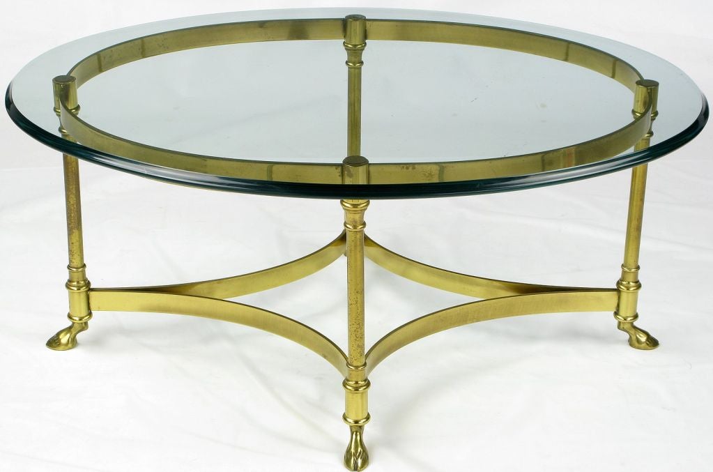 Exquiste small cocktail or coffee table by Labarge. The base is made of solid brass with arched strechers and hoofed feet. The glass top is ogee edged with a 1/2