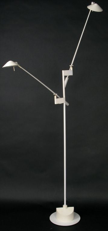 An early halogen double arm floor lamp from artistic lighting pioneer George Kovacs. Articulated arms and a carved wood base, all lacquered in white, make for a striking reading light.