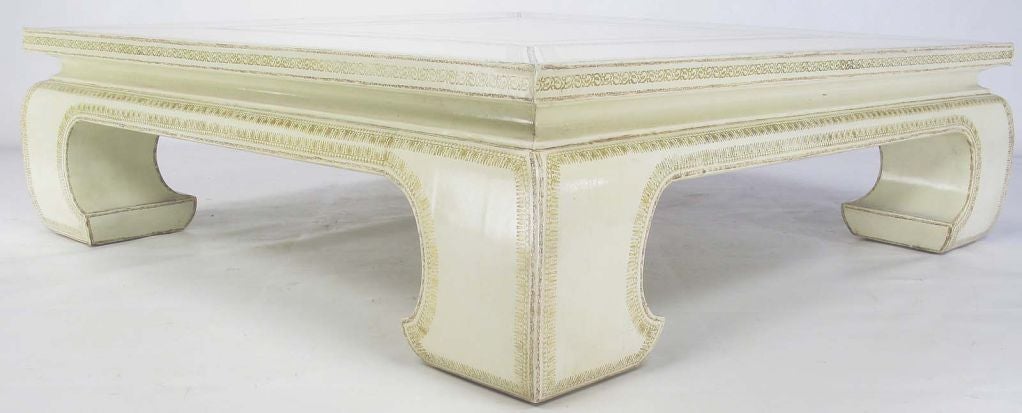 Sizable Asian form-coffee table from Maitland Smith. Every inch of this coffee table is clad in hand tooled ivory leather, with gilt and natural borders.