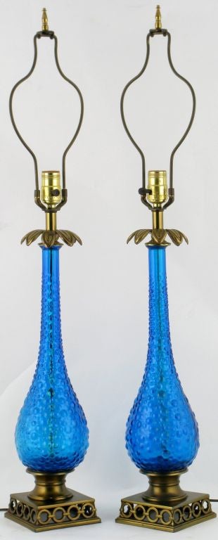 An exquisite pair of blue bubble glass gourd-form table lamps with open brass bases of interlocking rings and floral brass accents. Sold sans shades.