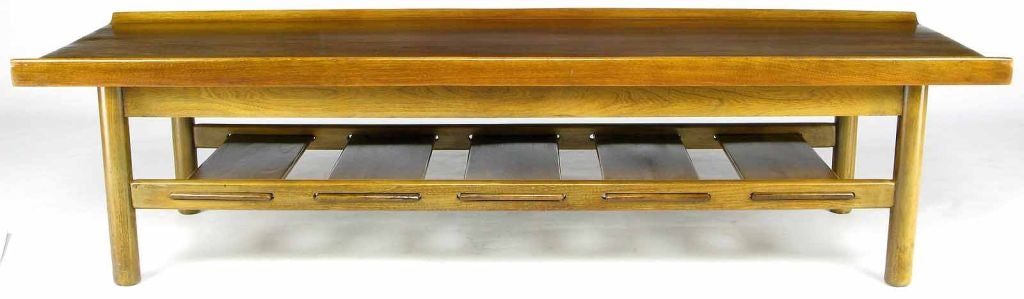 Usable as a bench or coffee table, this striking piece has upturned front and back edging, as well as slats below for storage.  A black button tufted fabric cushion completes the bench.  Made by Richardson Brothers Furniture of Sheboygan, WI.<br