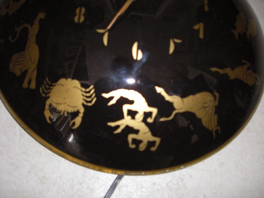 A reverse painted convex glass 1940's wall clock representing the Zodiac. Gold on a black background with brass dials. Still has its original (working) wiring. Made by the 