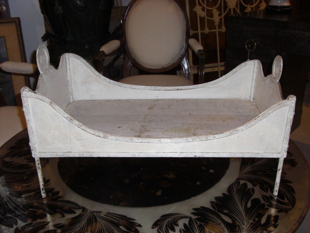 19th century riveted sheet iron dog or doll's bed in original white paint. Has un-identified manufacturer's marks.