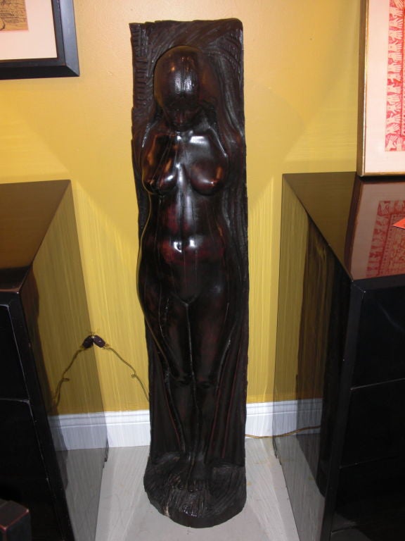 An interesting free standing, 1970's female nude sculpture carved in a solid log. It is very inspired by Art nouveau nudes. It is unsigned but the carving is competent and has a lot of softness to it.