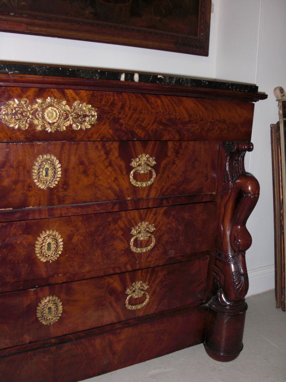 A premier example of a late Empire/early restauration 3-drawer  crotch mahogany commode with exquisitely carved swans on its sides and fine quality gilt bronze hardware. The number of fine design details on this commode and the overall quality of
