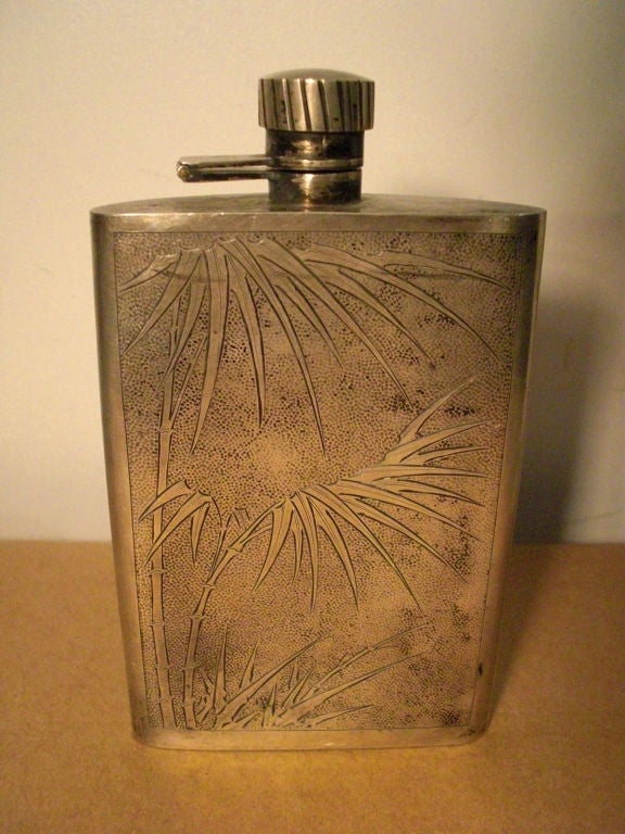 A well made arts and crafts or deco hand hammered silver hip flask with bamboo motif signed S K Wong and monogrammed JFS.It has a well designed hinged and screw down top. Also there is a charming inscription that reads 