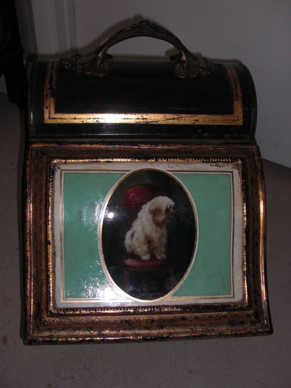 an exceptional example of and English tole stencil decorated coal hod or bin with an eglomise front panel of a pensive terrier sitting on a victorian parlor chair upholstered in red.