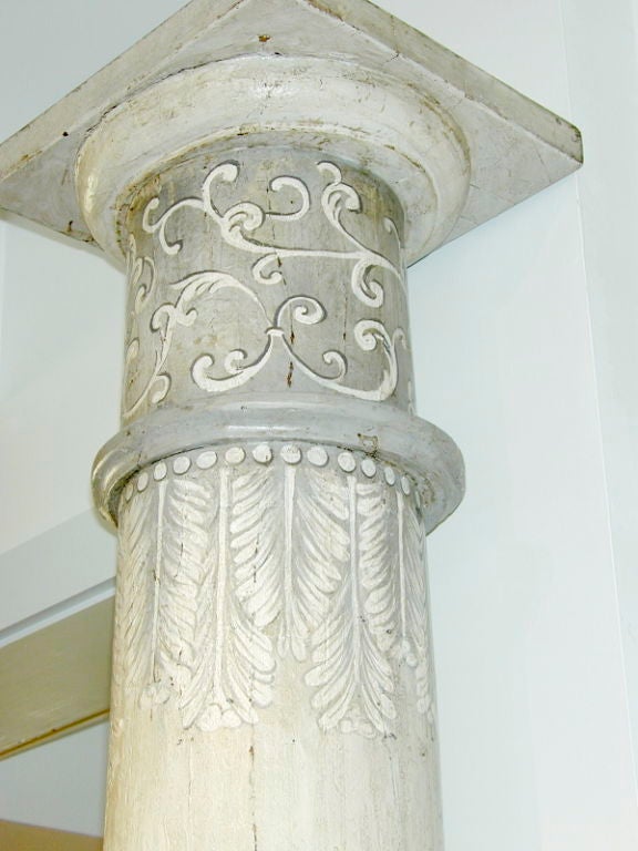 A pair of grey painted tromps l’oeil columns. These impressive pieces were painted by an accomplished artist to give the impression of fluting and a sense of dimension. The tops are decorated with a fanciful scroll above series elegant feathers in