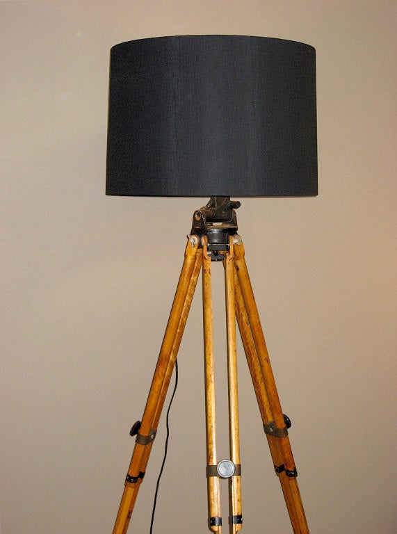 A large adjustable floor lamp made from an antique <br />
wood surveyor tripod. <br />
Made for the United States Army by Bell & Howell Company<br />
Chicago, Illinois.<br />
Includes a large custom silk and gold foil lined 24