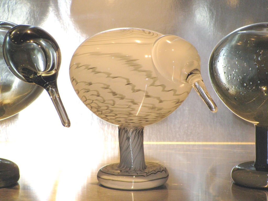 A trio of cute glass Kiwi Birds<br />
created by artist Oiva Toikka<br />
for iittala, a famous glass works company<br />
in Nuutajarvi, Finland.<br />
Two of the birds are a translucent smoky grey,<br />
and one is a white and grey swirl