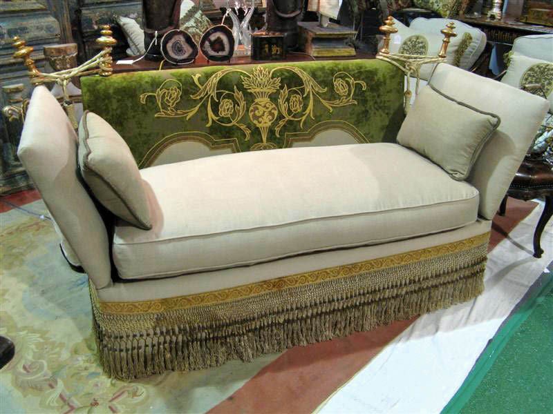 Knoll style sofa that has been reupholstered in flax colored linen with an antique embroidered velvet textile inserted in the the back. The finials are antique giltwood Italian. The fringe along the bottom is also from the 19th century. The arms go