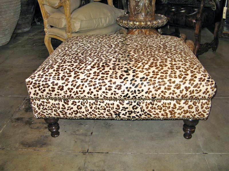 Faux leopard printed upholstered ottoman.  Great statement piece in any room!