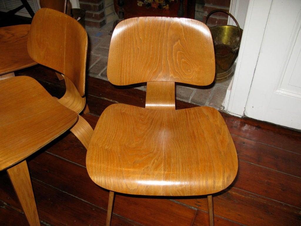 An amazing set of four  calico ash DCW's in incredible unrestored condition including all four original large seat back bushings. Wood grain is some of the nicest we have ever seen.  Two of the chair retain their Evans labels and two have the