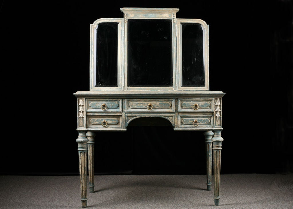 Beautiful Provencal style patinated and distressed vanity with rectangular top and triptych mirror above a 5-drawer frieze above turned and fluted legs.
