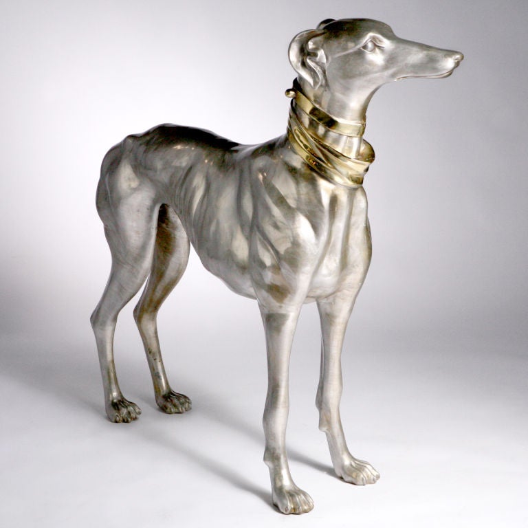 Exquisite life-size pair of hand-cast bronze greyhound dogs with gold tone collars that complement the nickel-plated finish.  This French design depicts each dog in a different elegantly poised position.  Limited edition.