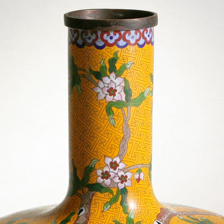 Vintage Chinese export cloisonne tall-necked vase with traditional orchid motif on yellow ground.  Separate rosewood base.