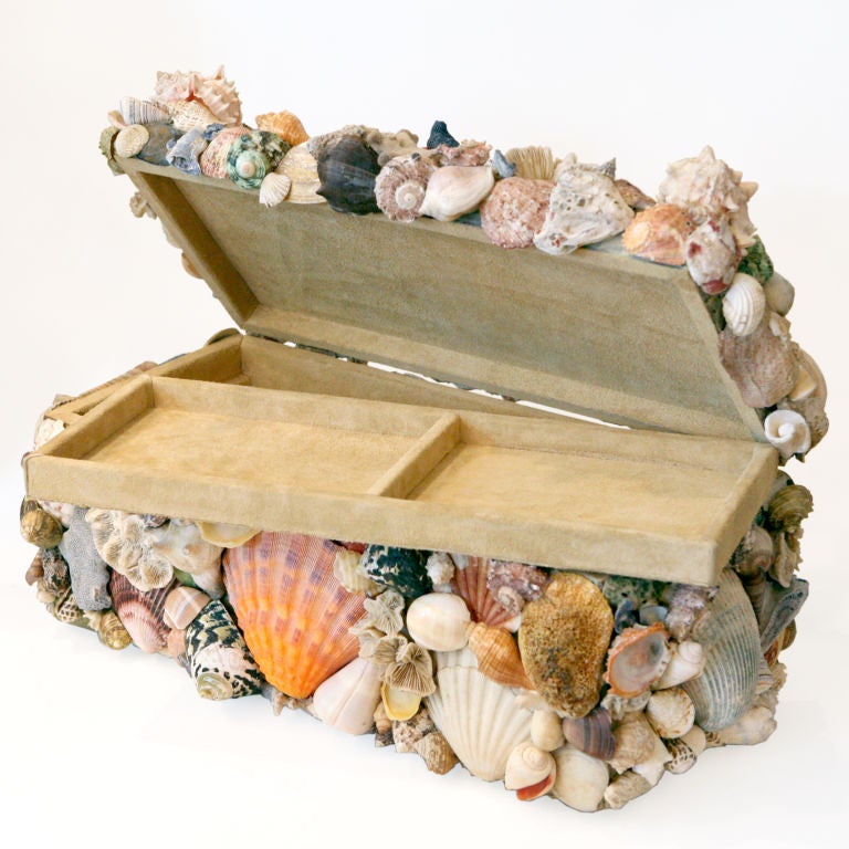 Seashell tabletop or jewelry box heavily encrusted with naturally worn shells including conch, scallop, sea urchin, sponge, starfish and several types of coral. The interior of the box is lined in a creamy suede fabric and features a set in tray.