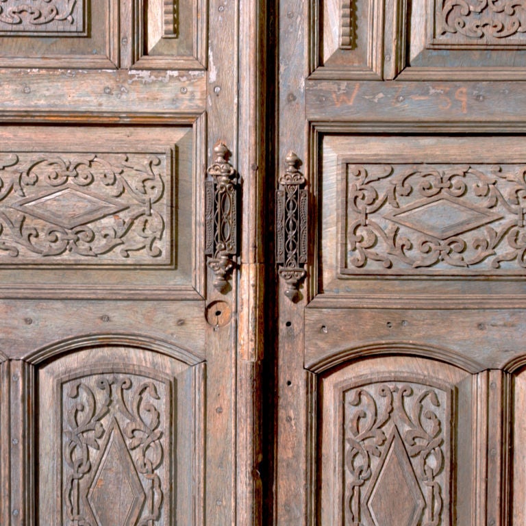 Massive intricately carved Moroccan door with frame. Impressive door is complete with original hardware and eight panels carved with scroll work design.