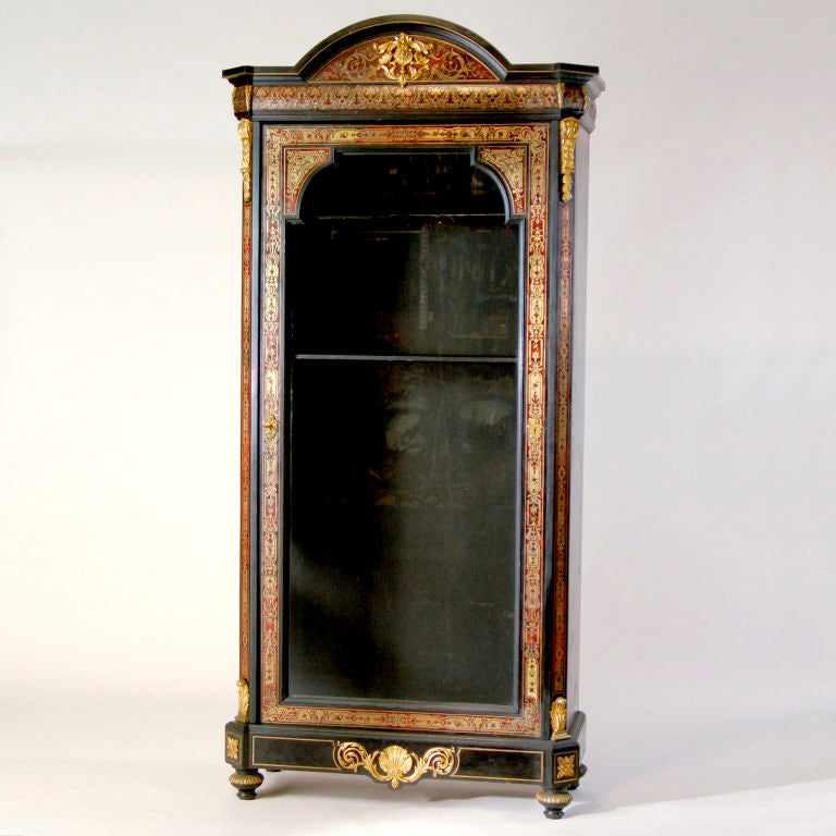 Napoleon III glass-fronted boulle cabinet with domed top. Features black lacquered wood, inlaid marquetry and decorative cast brass figural mounts.