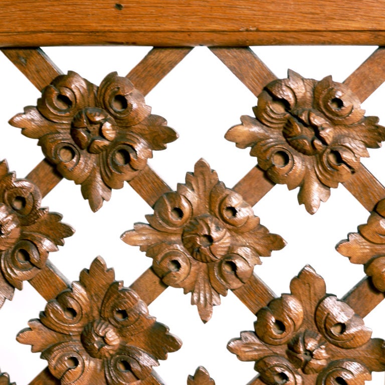 Unusual English four-panelled screen. Oak framing with decorative frette work of stylized flowers crowned by carved scroll top piece. Each panel: 83