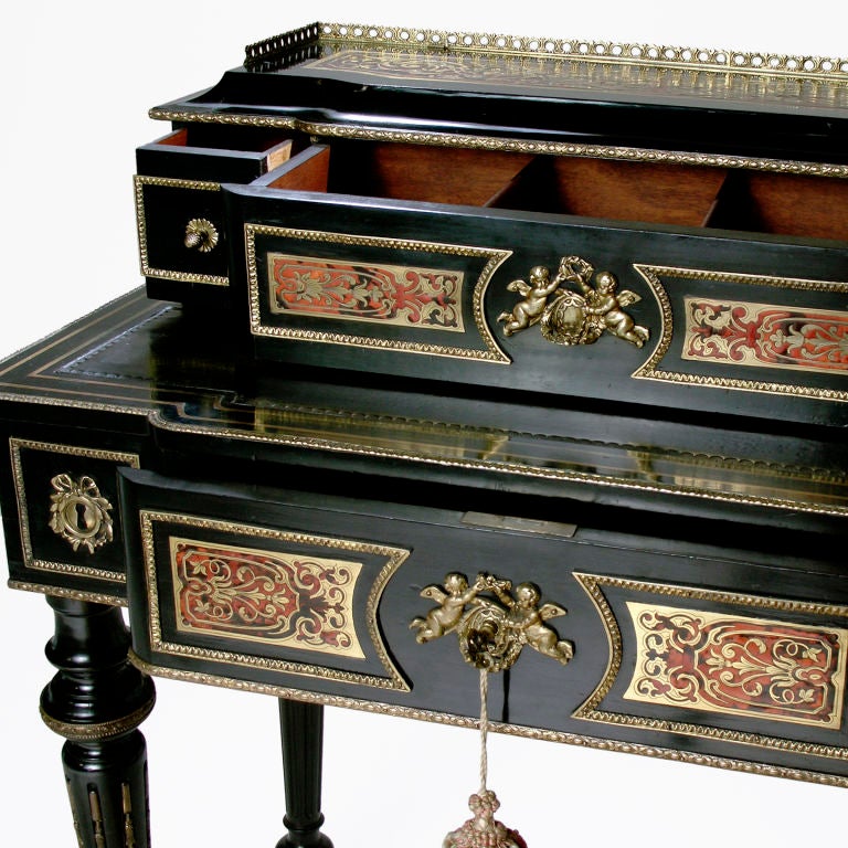 Well-proportioned French black lacquer and Boulle writing desk with metal gallery raised back. Writing surface covered in leather, and drawers with original hardware. Raised on carved spindle legs.