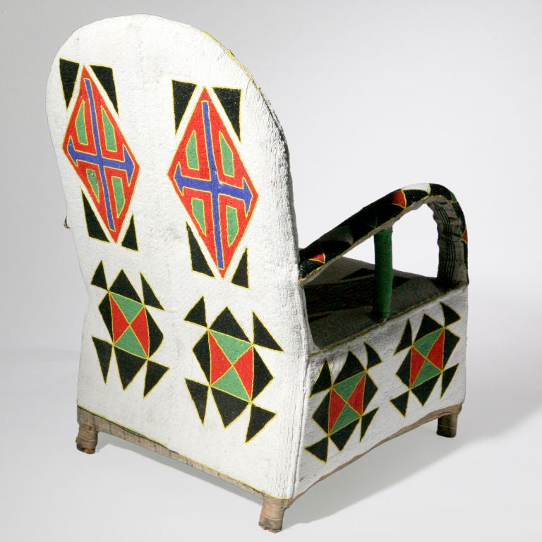 Exquisitely crafted Nigerian chair in vivid colors. Hand-upholstered beads create a vibrant pattern with geometric shapes.  Each chair a work of art individually crafted.