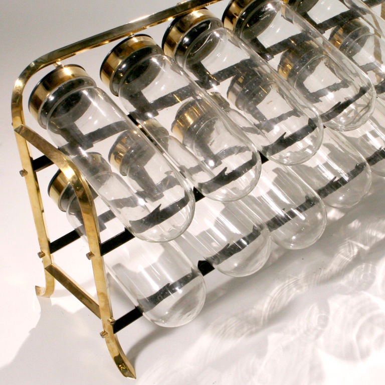 Old fashioned glass jar candy display rack can be creativity used to showcase any collection!  Set of twelve jars with attached hinged lids that sit on a free standing brass display rack.