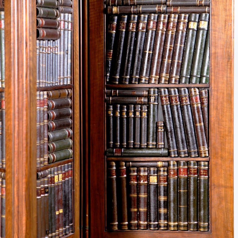 English mahogany four-panel book screen with hand-painted faux book spines and original hidden gun barrel hinges. An antique screen refitted: The front having leather bound books, the back covered with vintage burgundy damask fabric set into upper