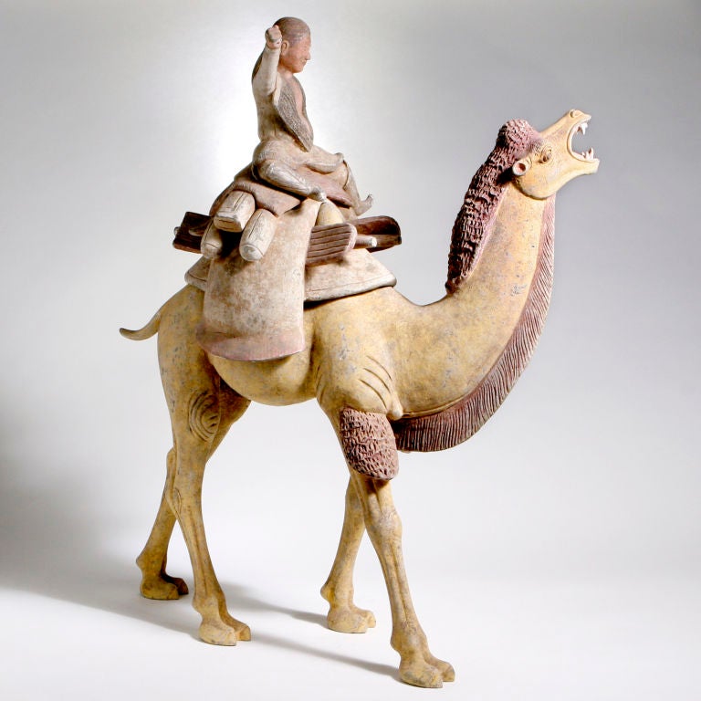 Tang Dynasty (AD 618-907) Chinese gray pottery camel with separate rider and ornate saddle. The braying animal naturalistically modelled with large pack, pack boards and pilgrim flasks.  The folded cloth under the saddle with traces of red pigment,