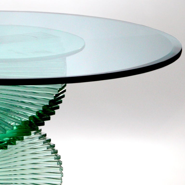 Truly unique green glass table with magnificent spiral pedestal base.  The top of the table is bevelled and features a gracefully rounded edge.  The pedestal base is composed of rectangular glass pieces stacked to resemble a spiral staircase.