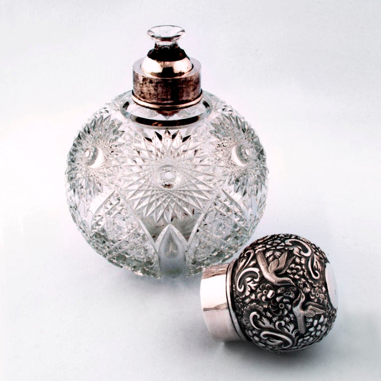 Rare extra-large Victorian cut crystal perfume bottle with sterling silver top and small crystal vial insert. Crystal body in beautiful leaf and flower pattern, hallmarked silver top detailed with birds, leaves and flowers. Hallmarked: London 1890.