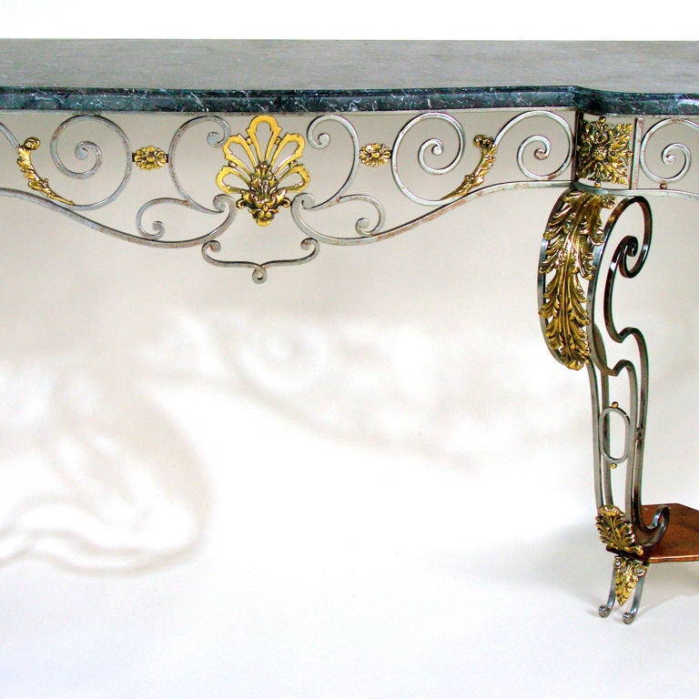 Striking seven and a half foot long polished steel wall console from the mid-19th century. Variegated gray marble top has Classic ogee edge. Graceful scroll patterned apron accented with bronze detailing. Bulbous legs with stylized bronze acanthus