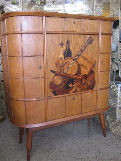 One of a kind Deco Bar/sideboard/console/credenza. Marquetrie musical intruments, with slight brass inlay definition. Panel like finition on extrerior, Swivel central door, top drawer, bottom flap down, right end left doors, all opening to the