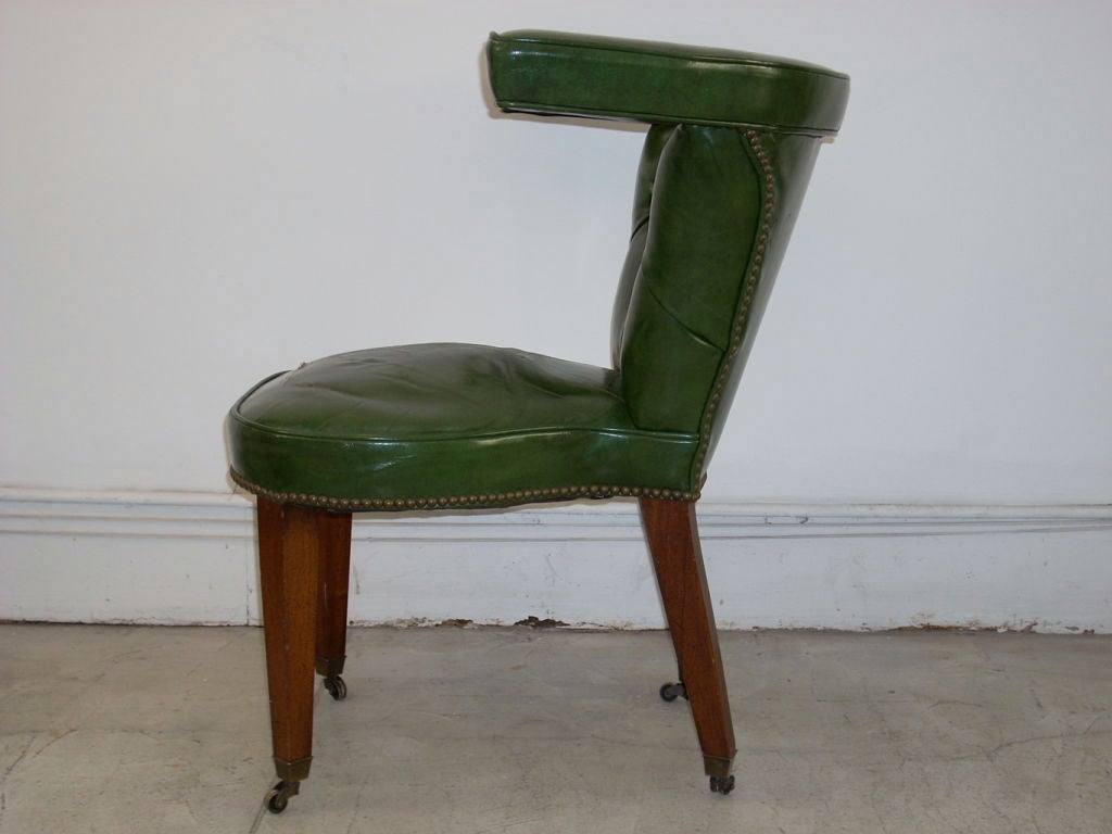 This is a unique green leather desk chair designed to sit forward or backward with your arms on horseshoe back.