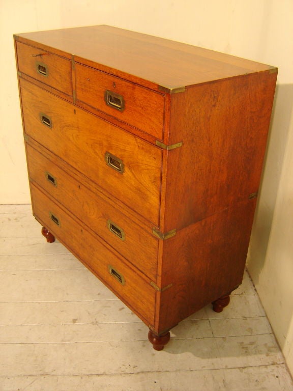 This fine teak 2 piece chest was made by The Army and Navy Co-operative Stores Limited at around the time they opened in 105 Victoria Street, Westminster, London. They made and sold all kinds of officers travelling furniture from beds to tables and