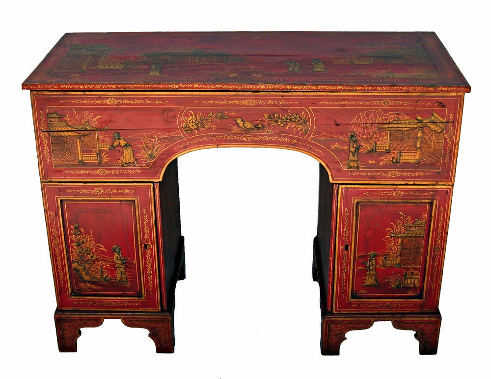 English Red Lacquer Hinged Top Chinoiserie Kneehole Desk, C1840, the hinged top opening to a  leather lined writing surface with fitted storage space beneath, the base with 2 cupboards, one fitted with 2 shelves the other fitted with 3 drawers;