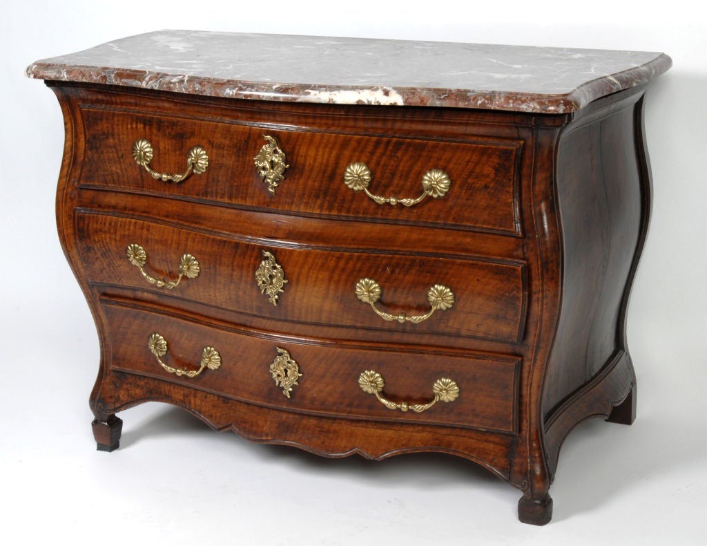 A Régence diminutive bombé commode striated walnut, with a rare molded serpentine Breccia marble top over a conforming Bombé base, consisting of three long drawers with brass handles and escutcheons, reeded sides and carved apron, raised on short