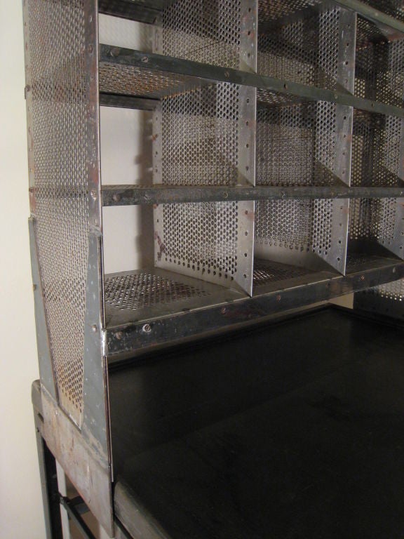 vintage postal sorter, top divided section pulls forward on track, lower level has flip down dividers, attached stool on pivoting arm