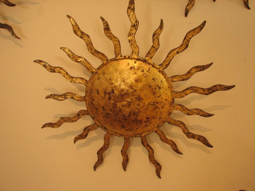 Charming hand wrought, gilded iron sunburst sconces with hand hammered surface. Each slightly different.From a hotel in Nice.4 pairs,1 single avaliable sold in pairs.