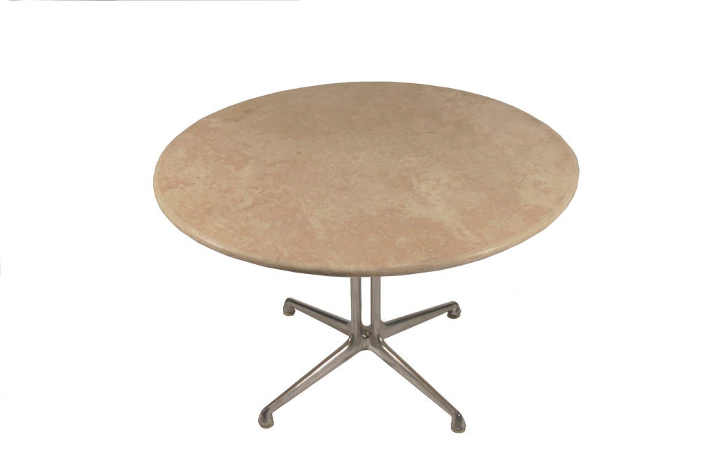 Round travertine top on aluminum base. Made by Herman Miller.