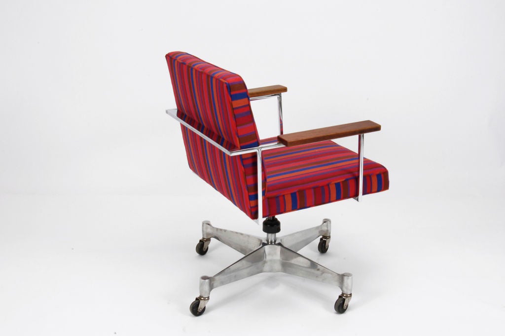 Steel Frame desk chair with walnut armrests, on tilt and swivel caster base. Reupholstered in original Alexander Girard fabric. Retains label.