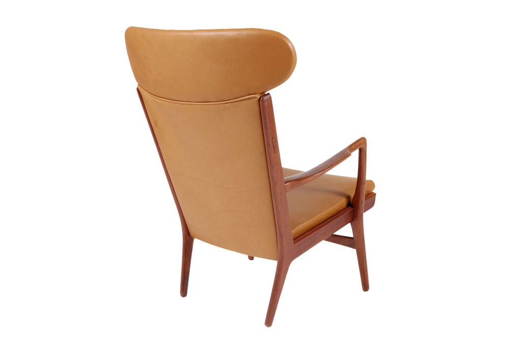High back easy chair with solid teak frame and new tan leather upholstery. Rare Wegner design. Made for AP Stolen.