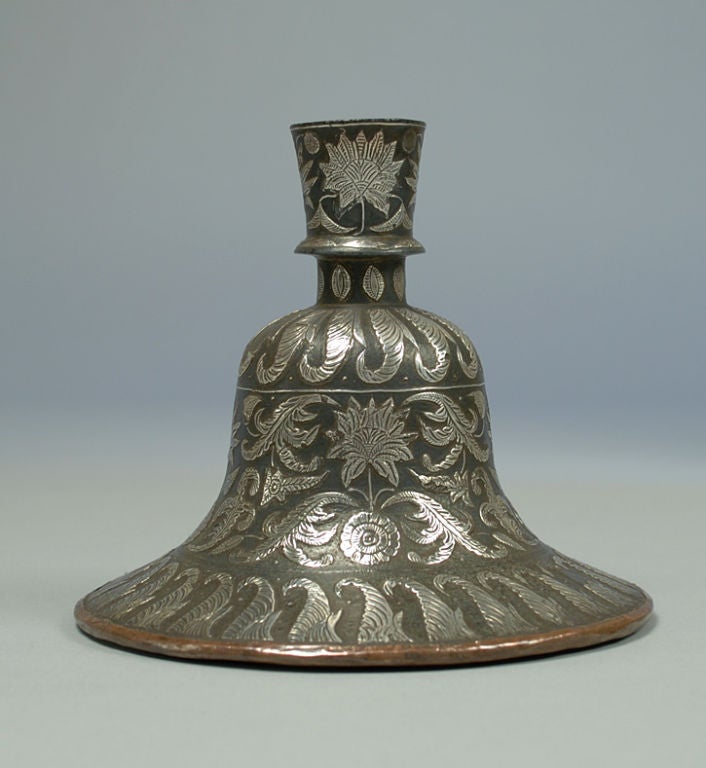 This extremely fine 18th century Indian silver inlaid bidri huqqa bottle of bell form is decorated with panels of inlaid silver flowers within geometric and foliate patterned borders. There are four main stages in the manufacture of Bidri. They are
