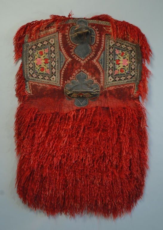 This exceptionally rare early 20th century saddle cover from West Anatolia (Kuthaya) is made entirely from madder dyed angora wool, felt, leather and silk. The leather elements, including the horn, the seat cantle and the saddle sides are stitched