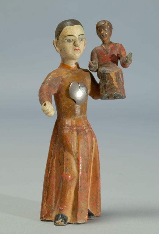 A charming 19th century Spanish colonial carved and polychrome painted wood santo with inset glass and silver sacred heart milagro.<br />
<br />
Dimensions: measures approximately 7.75 inches high.