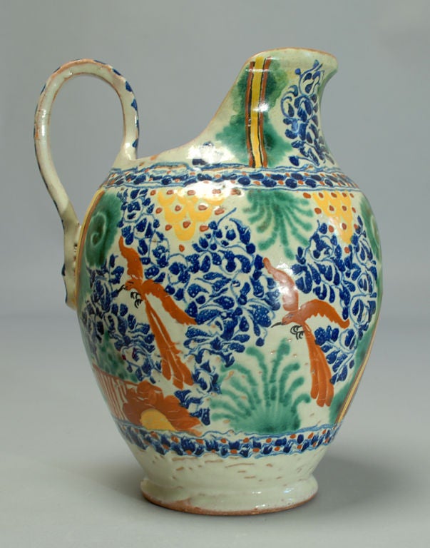 A superb 19th century Mexican talavera Poblana handled pitcher with deep cobalt blue foliate motifs, copper green agave, yellow scales and terracotta red Quetzal parrots throughout.<br />
<br />
Dimensions: 12.25 inches high x 10 inches diameter.