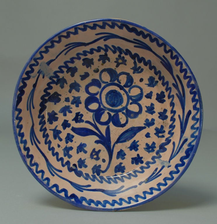 A good mid 19th century Granadino Fuente charger from Granada, Spain. This classic blue and white Spanish charger features a large flower blossom surrounded by foliate motifs. Deep cobalt glaze over a salmon / white slip.<br />
<br />
Dimensions: